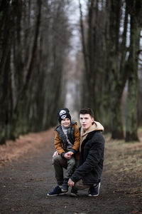 Full length of young man with boy in forest
