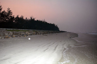 Scenic view of beach against clear sky during sunset