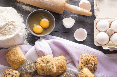 Close-up of flour by bread and rolling pin on table