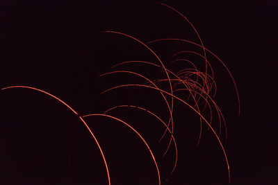 Low angle view of light trails against sky at night