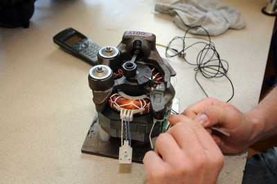 Midsection of man repairing electric motor