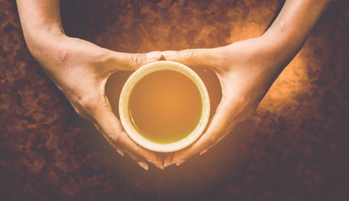 Low section of woman holding coffee cup