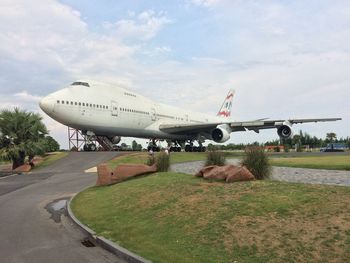 Airplane on airport runway against sky