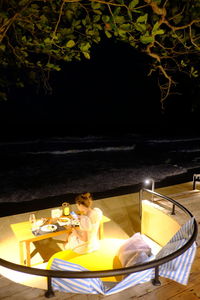 Woman sitting by swimming pool