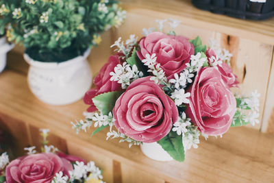 The sweet rose on the wooden shelf