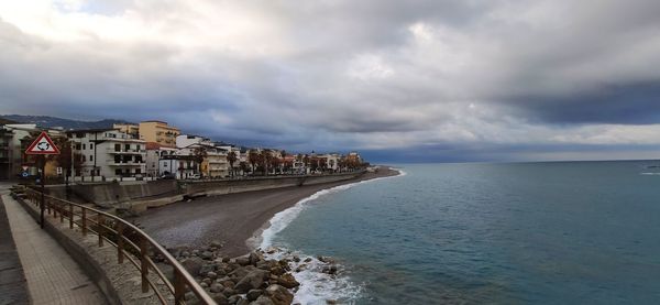 Buildings by sea against sky in city