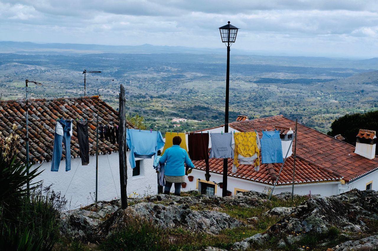 building exterior, architecture, built structure, sky, real people, building, day, nature, residential district, rear view, house, mountain, men, cloud - sky, people, roof, lifestyles, outdoors, lighting equipment