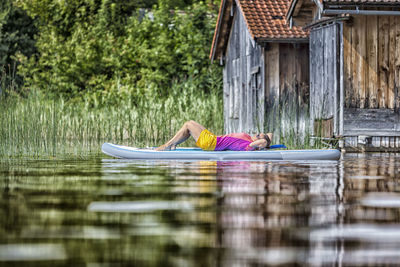 Woman relaxing on paddleboard in lake