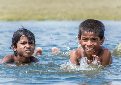 Portrait of smiling boys swimming in lake