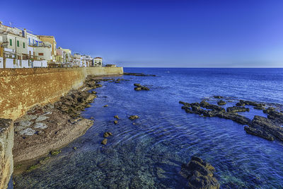 Scenic view of sea against clear blue sky