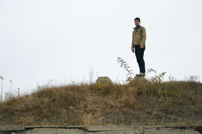 Man standing on field against clear sky