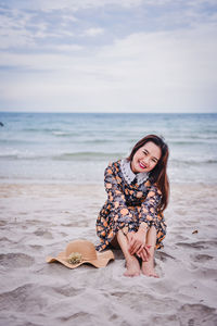 Woman wearing sunglasses on beach against sky