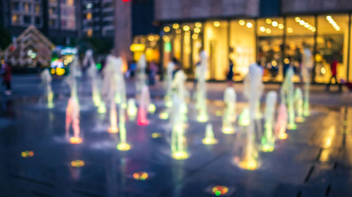 Defocused image of people on illuminated city street at night