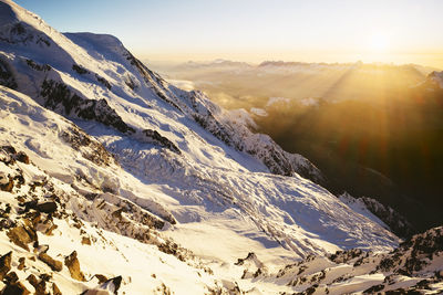 Sun shining over snowcapped mountains