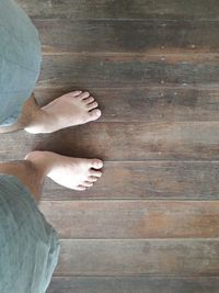 Low section of woman standing on wooden floor