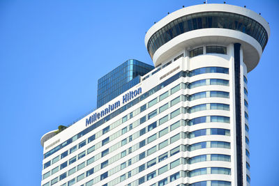 Low angle view of modern building against clear blue sky