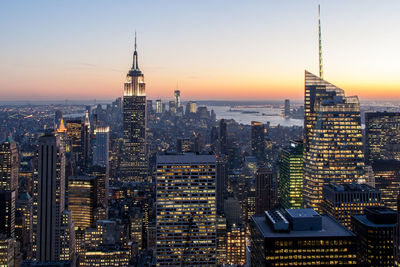 Aerial view of illuminated buildings in city during sunset