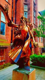 Statue of woman in front of building