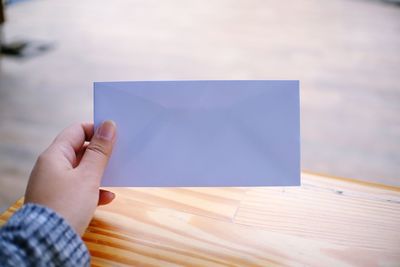 Close-up of hand holding envelope