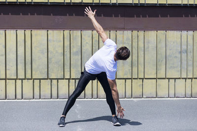 Confident young man exercising during sunny day