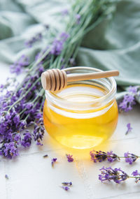 Glass of honey, honeycomb and lavender flowers