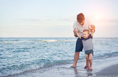 Full length of father and daughter on beach