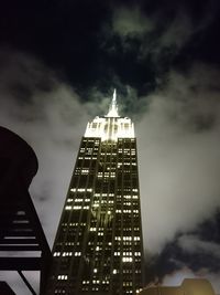 Low angle view of illuminated building against cloudy sky