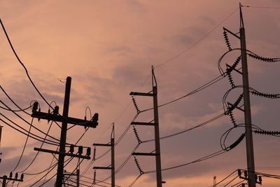 Low angle view of silhouette electricity pylon against sky during sunset