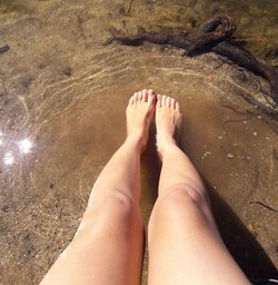 Low section of woman relaxing on beach