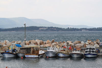 Boats in sea with mountain range in background