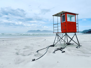 Lifeguard hut on beach against sky