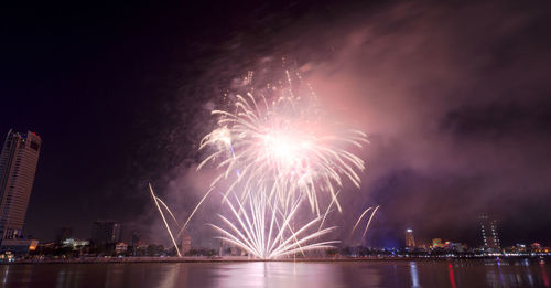 Firework display over river at night