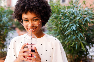 Smiling teenage girl drinking drink