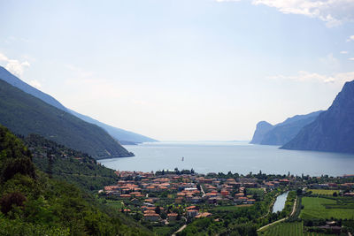 Scenic view of town by sea against sky