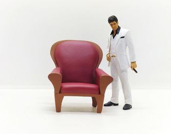 Rear view of man sitting on chair against white background