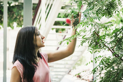 Beautiful agronomical engineer observing the plants in the greenhouse