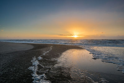 Scenic view of beach against sky during sunset