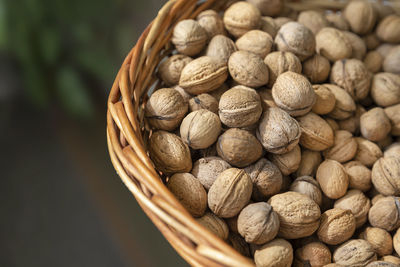 Basket full of organic unshelled walnuts, harvest season. closeup top view.