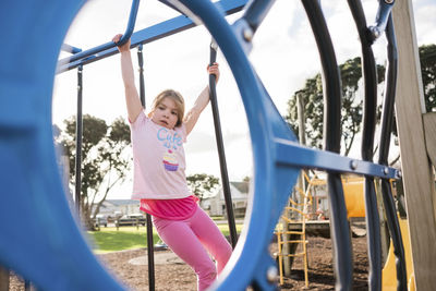 Full length portrait of smiling girl playing on playground