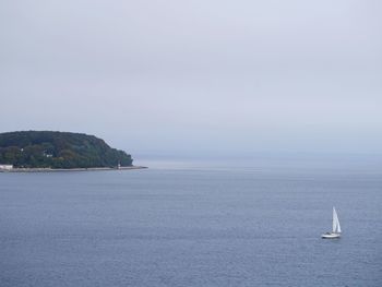 Sailboat sailing on sea against sky