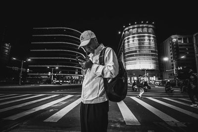 Full length of man crossing road at night