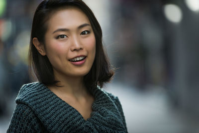 Close-up portrait of smiling young woman outdoors