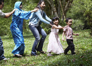 Portrait of smiling family playing on grass