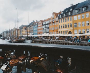 Close-up of padlocks on bridge over river in city