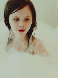 Thoughtful cute girl looking away in bathtub