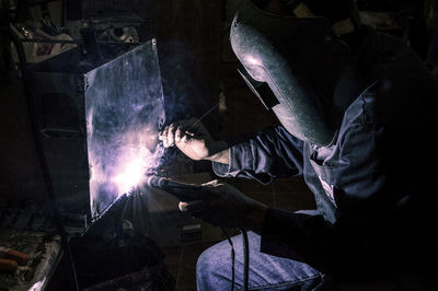 Man working on metal in container