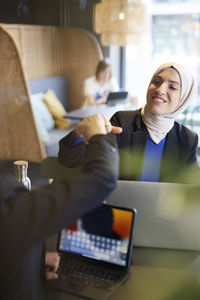 Woman in headscarf sitting in cafe