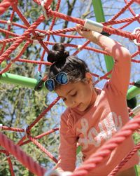 Low angle view of girl playing on jungle gym at playground