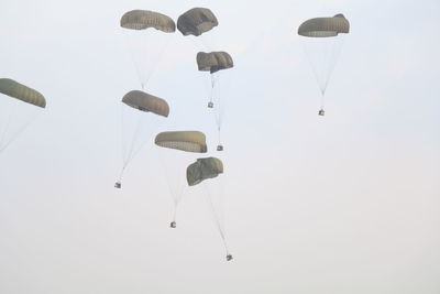 Low angle view of air  drop paragliding against sky