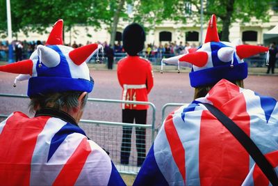 Rear view of people in british flags by street during celebration